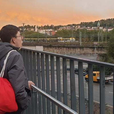Ein Schüler erblickt im  leuchtenden Abendrot den Zugverkehr in Stuttgart