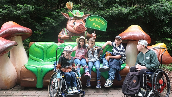 Fünf Schüler sitzen vor der Wutzel-Figur des Kurpfalzparks