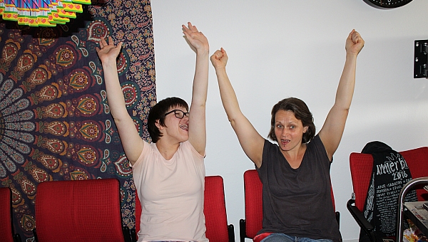 Eine Betreuerin und eine Schülerin halten die Hände in hoch 