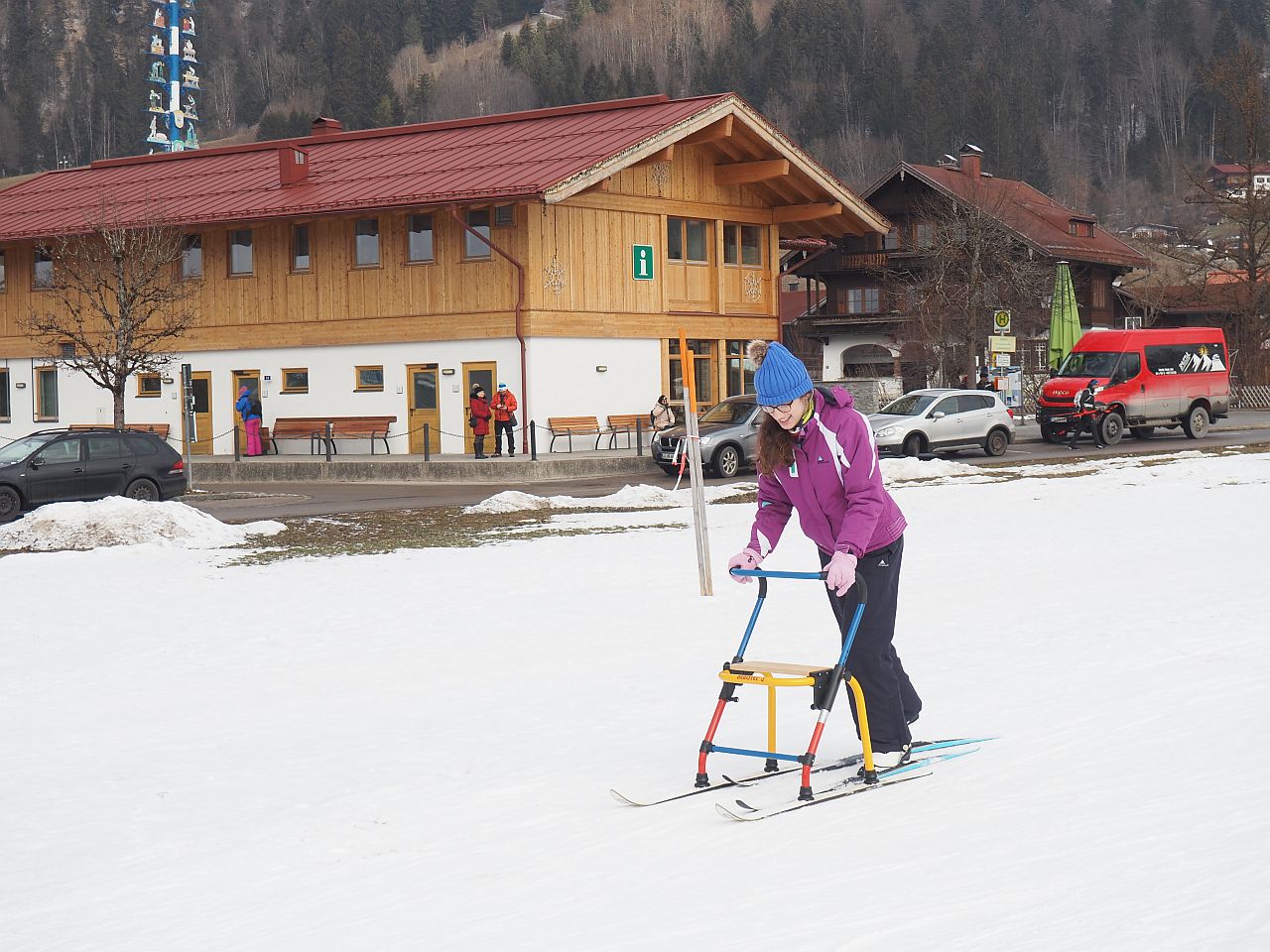 Ein Mädchen mit Rollator läuft auf Langlaufskiern.