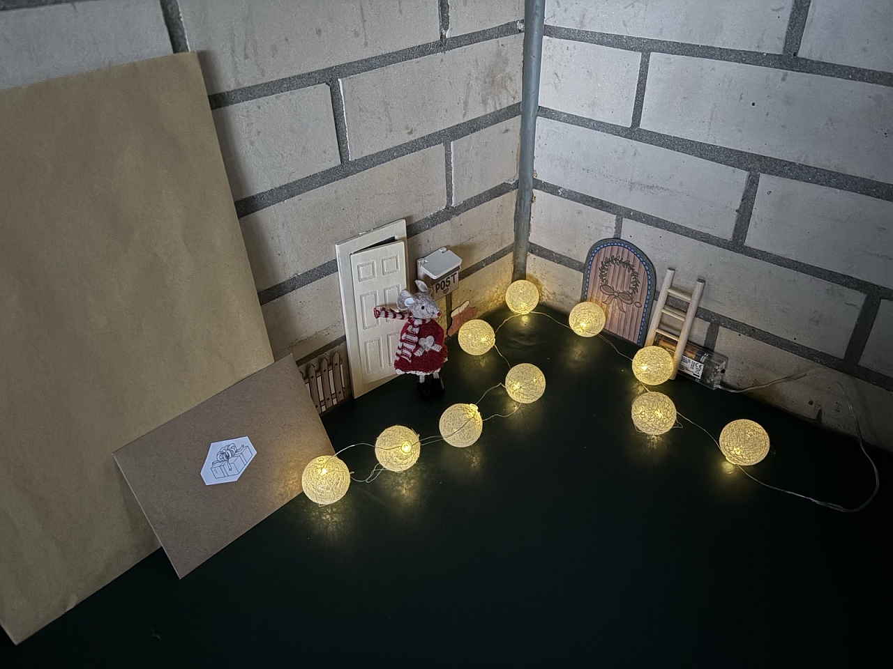 Ella steht vor der Türe, ein Briefkasten ist zu sehen.