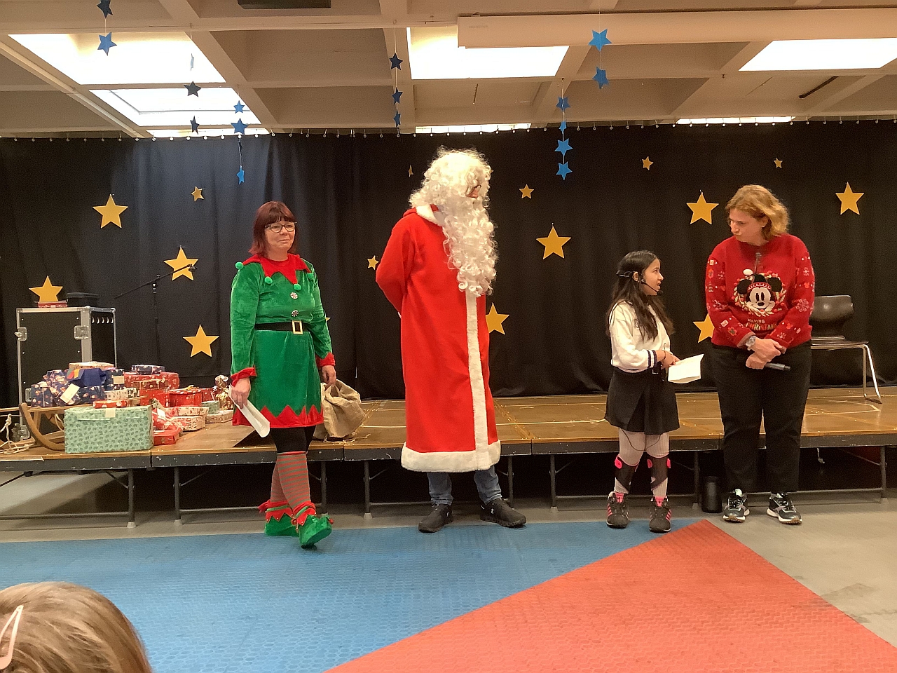 Schülersprecherin und Direktorin begrüßen den Weihnachtsmann und seinen Wichtel der Firma Mahle