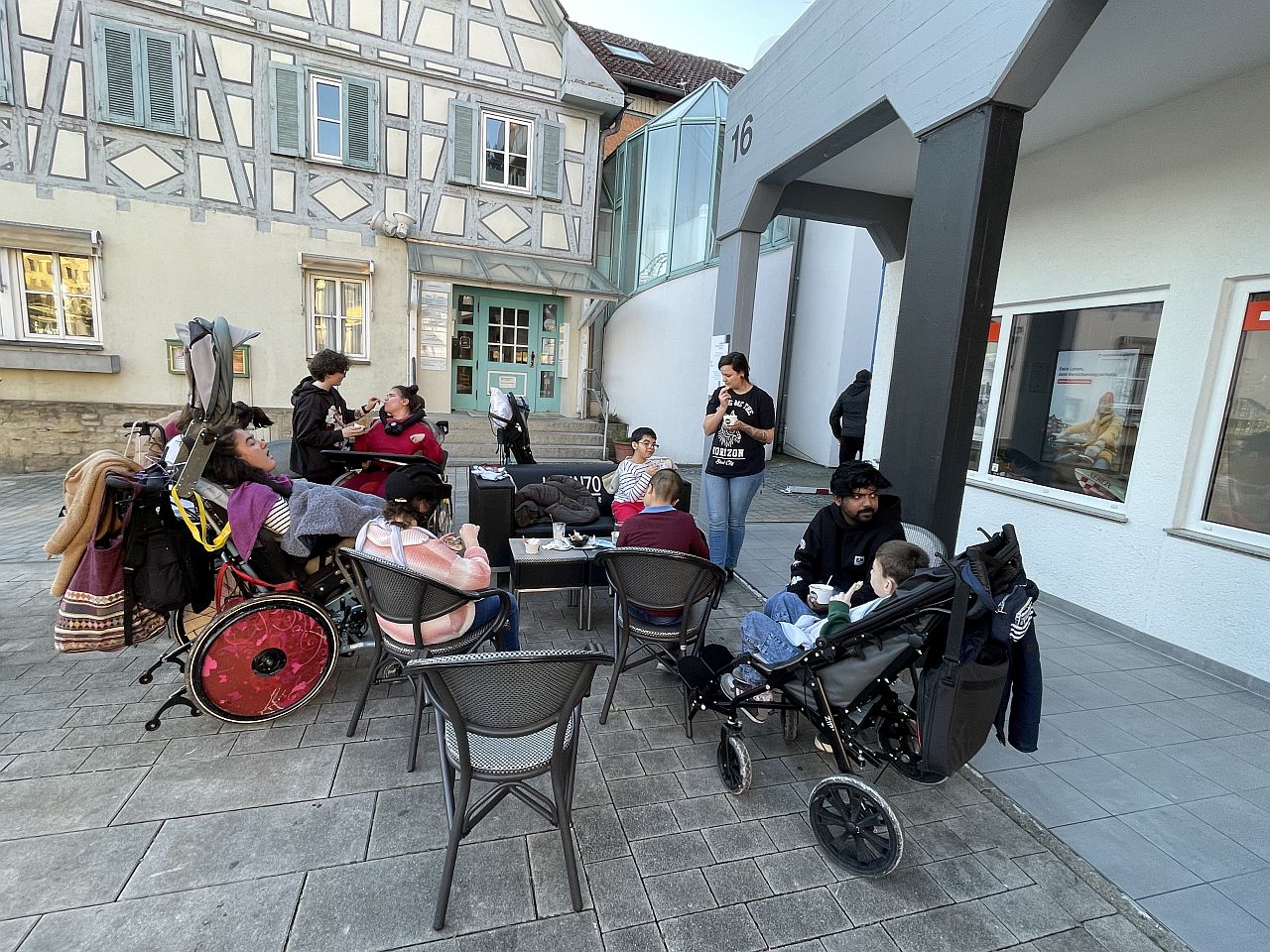 Eine Gruppe von Menschen sitzen im Kreis und essen ein Eis. Einige sitzen im Rollstuhl.