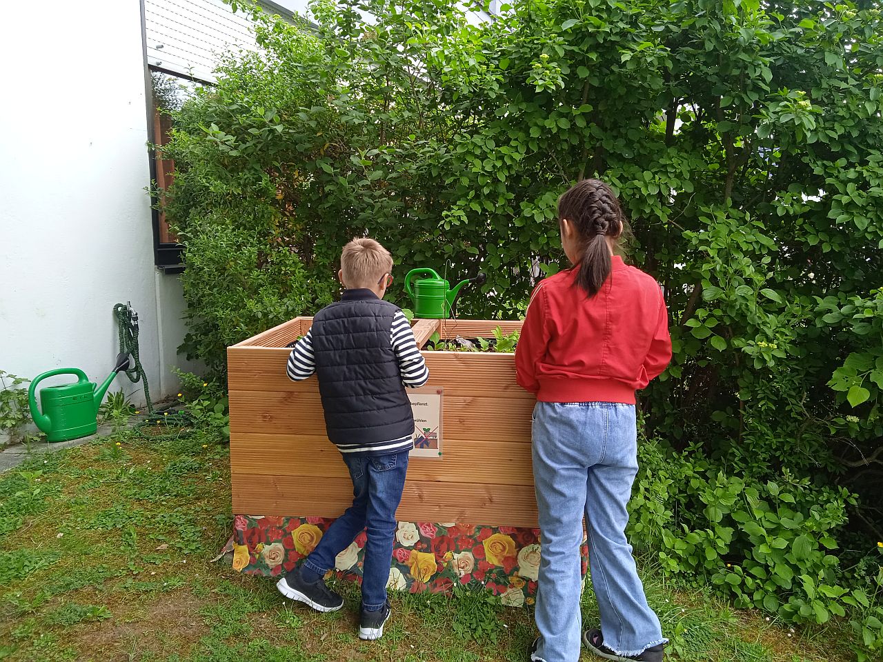 Zwei Kinder stehen vor dem neuen Hochbeet
