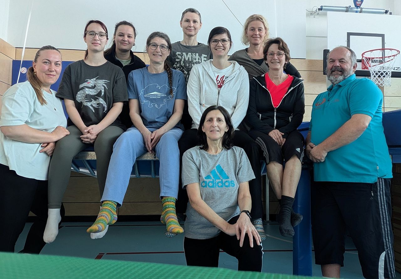 Gruppenbild mit 10 Personen auf dem Trampolin und lachen in dei Kamera