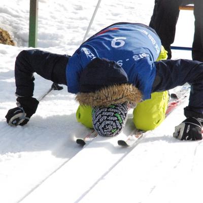 Florian kniet auf seinen Skiern in der Loipe und hat den Kopf auf den Schnee gesenkt.