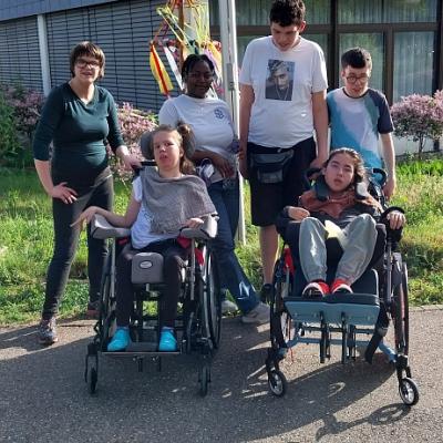 Fünf Schüler, zwei im Rollstuhl und eine Mitarbeiterin vorm Maibaum