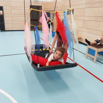 Eva schaukelt in Bauchlage.