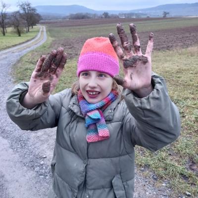 Glückliches Mädchen mit matschverschmierten Händen