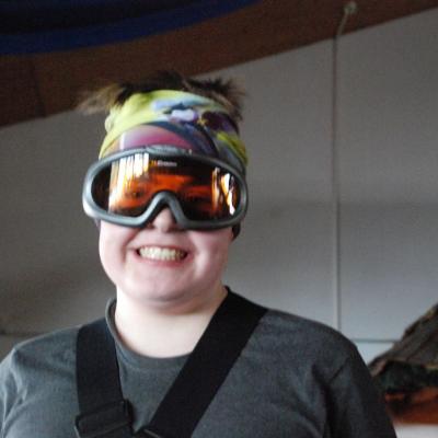 Christopher trägt seine Skibrille und hat sein Halstuch um den Kopf gebunden, sodass es lustig aussieht.