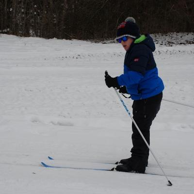 Josua läuft auf der Loipe und schaut in die Kamera.