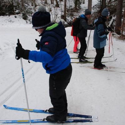 Josua läuft seitlich einen steilen Aufstieg neben einer Loipe hinauf. Dahinter kommen noch weitere Personen mit derselben Technik.