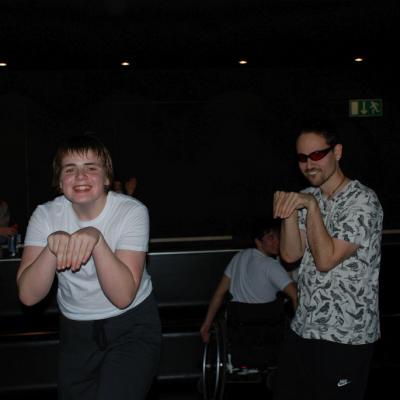 Christopher und Herr Kling tanzen im dunklen Disco-Raum, indem sie einen Hasen nachahmen. Herr Kling trägt seine rote Brille.