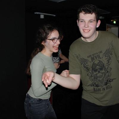 Marija und Julian tanzen im dunklen Disco-Raum und lächeln.