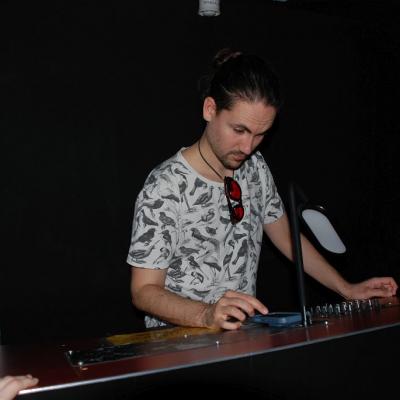 Herr Kling steht hinter dem DJ-Pult und wählt am Smartphone Lieder aus.