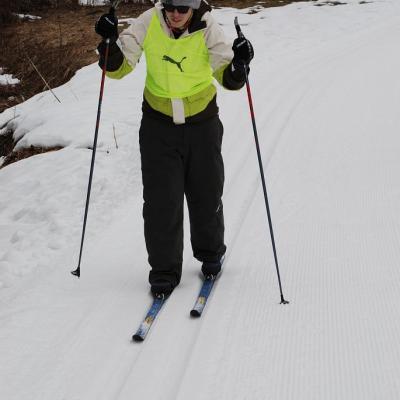 Marija kurz nach dem Start in das Abschlussrennen mit ihrem Skilator. Sie stützt sich auf dem Skilator auf und fährt zwischen zwei Spuren. Im Hintergrund sieht man noch die Hütchen welche die Startlinie markieren. 