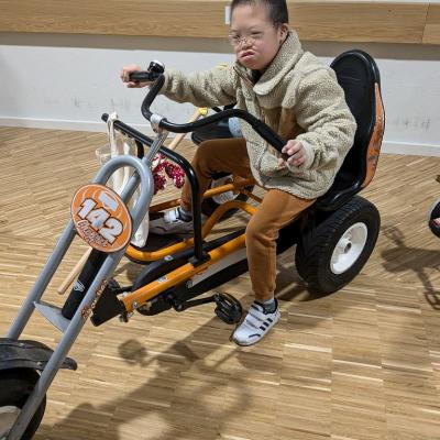 Ein Junge sitzt auf einem orangenen GoCart