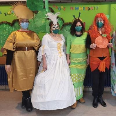 4 als Sonne, Mond, Raupe und Orange verkleidete Frauen, im Hintergrund „Raupe Nimmersatt“