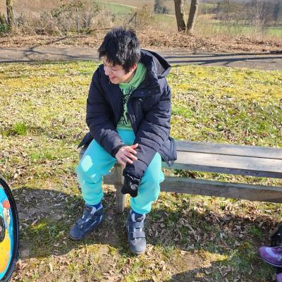 Schüler sitzend auf der Bang und genießt die Sonne 