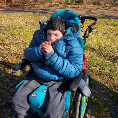 Schüler im Rollstuhl mit Händen vor dem Mund 