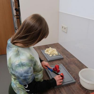 Ein Mädchen schneidet Erdbeeren.