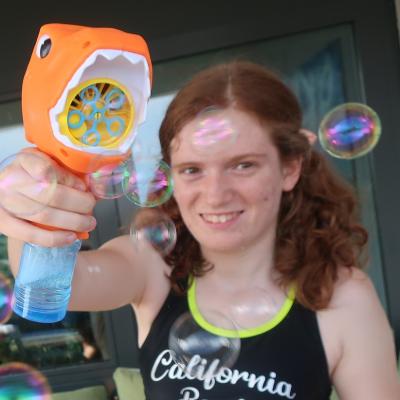 Ein Mädchen spielt mit einem Seifenblasengerät