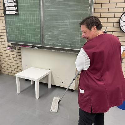 Eine Reinigungskraft mit Wischmopp