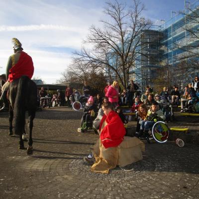 Der Bettler hat den halben roten Mantel um sich gewickelt, links im Bild Sankt Martin mit seinem halben Mantel von hinten