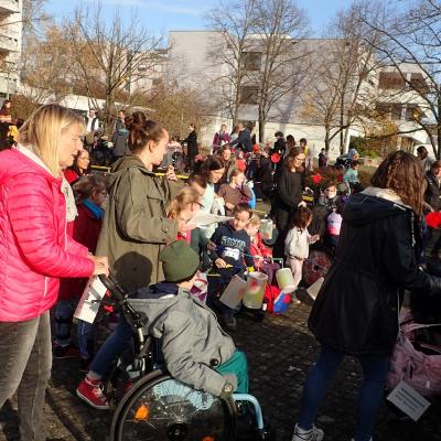 Menschenmenge aus Erwachsenen, Kindern und Jugendlichen, zum Teil mit Laternen