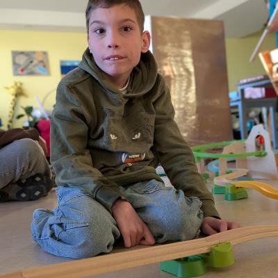 Ein Junge sitzt auf dem Boden und beobachtet die Kugelbahn