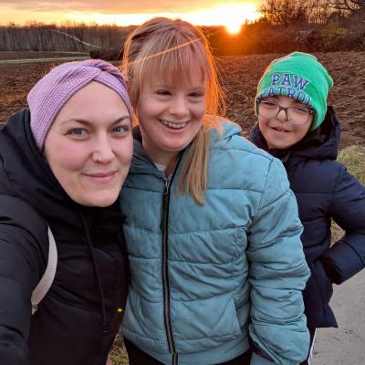 Eine Frau und zwei Kinder lachen in die Kamera