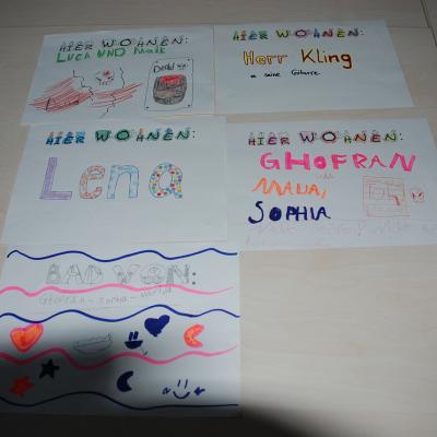 Auf einem Tisch liegen die fertigen Zimmerschilder mit den Namen.