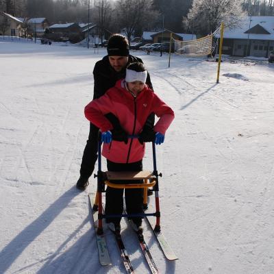 Ghofran fährt mit dem Skilator. Herr Kling stützt sie von hinten.