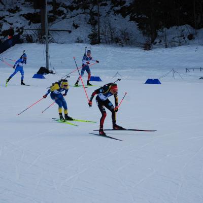 Zwei Biathleten liefern sich ein Sprint-Duell. Vorne einer mit deutschen Farben, dahinter einer mit ukrainischen. Dahinter sind zwei weitere.
