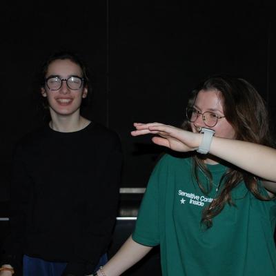 Marija und Lena tanzen im dunklen Disco-Raum und lächeln.