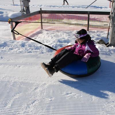 Marija sitzt in einem Reifen, der mit einem Seil vom Lift gezogen wird.