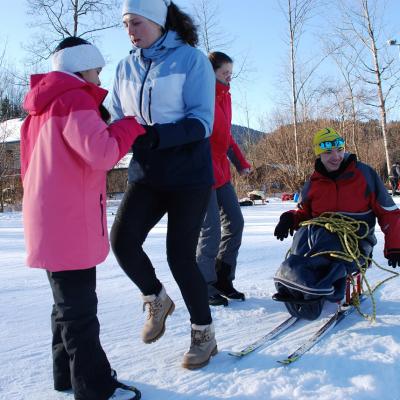Beim Aufwärmprogramm hält Ghofran Frau Feckes Hände und bewegt sich mit ihr. Dahinter bewegt sich Maik mit Lena. Er lächelt vergnügt.