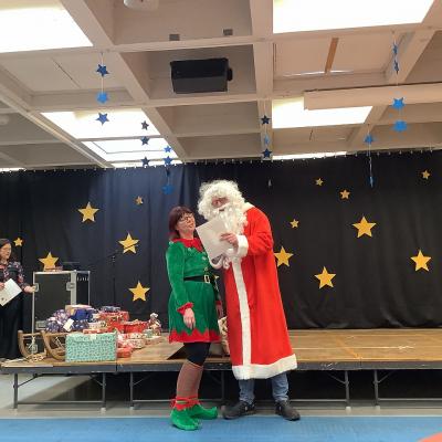 Weihnachtsmann und Wichtel tragen das Begrüßungsgedicht vor.