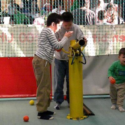 Ein Zwei Jungen stehen vor einer Ball- Kanonen in einem Indoorspielplatz 
