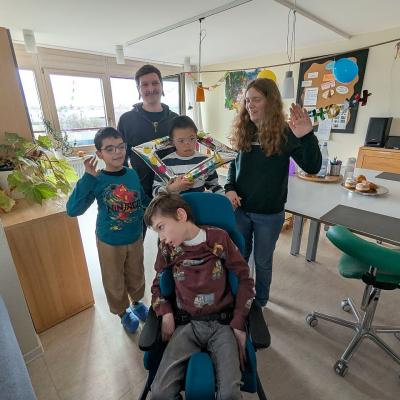 Gruppenbild: ein mann und 4 Schüler schauen lachend in die Kamera