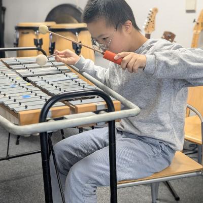 Ein Junge sitzt am Glockenspiel und spielt