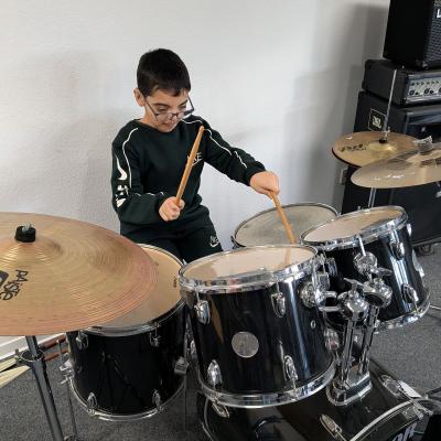Ein Junge sitzt am Schlagzeug und spielt