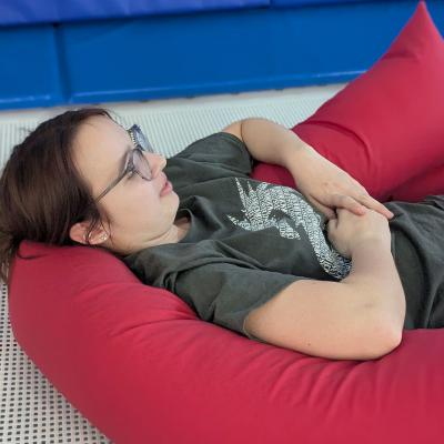 Eine Frau liegt auf dem Trampilin und ist gelagert