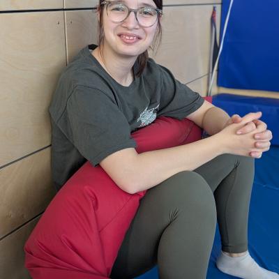 Eine Frau hält eine Lagerungsschlange und lacht in die Kamera