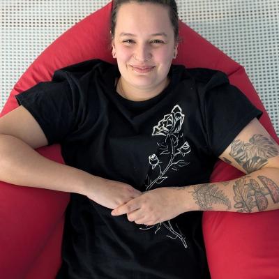 Eine Frau lacht in die kamera und liegt in einem Lagerungskissen drin