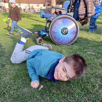 Schüler liegt auf dem Bauch auf dem Rasen und freut sich 