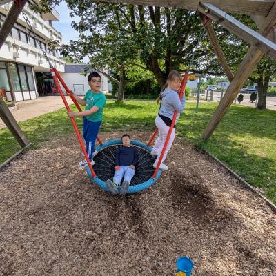 3 Kinder schaukeln in der Nestschaukel und haben Spaß