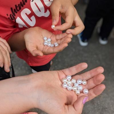 Kinder halten viele Zauberperlen in den Händen